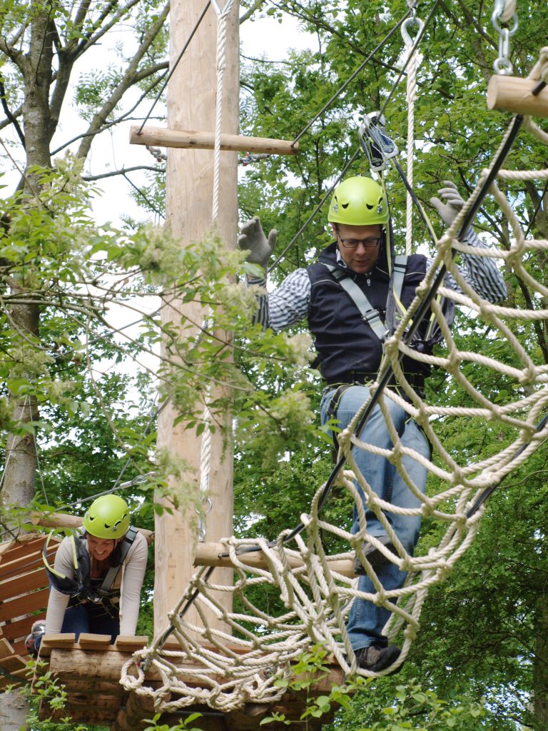 Man klimt over een net bij De KlimVallei in Den Helder